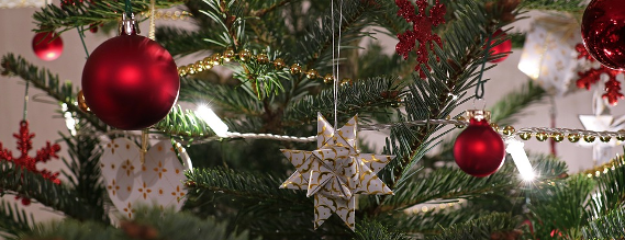 Nærbillede af et julepynt på et juletræ, blandt andet end rød glaskugle og en stjerne